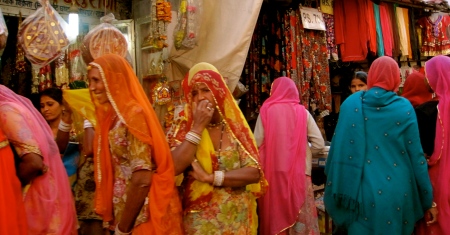 Brightly clad Rajasthani women in the market /bazaar.  Rajasthan desert folk are known for their colorful saris!